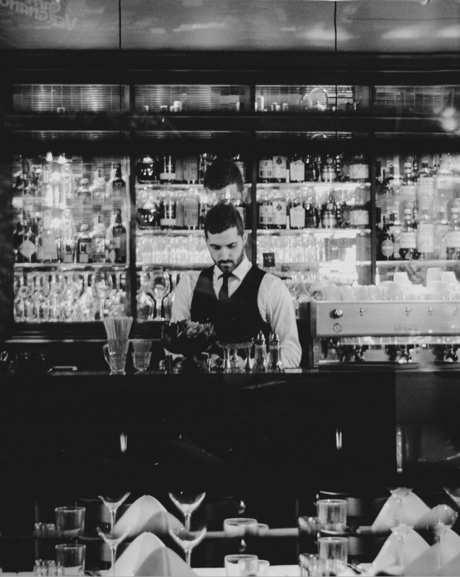 a man standing behind a bar